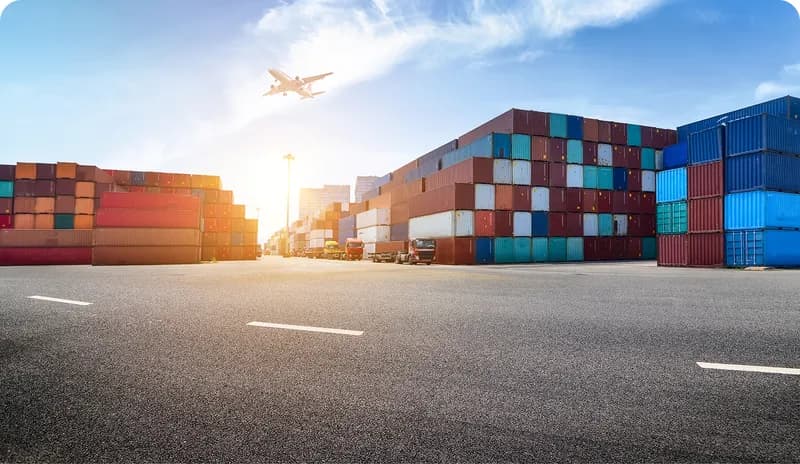 Container terminal with airplane flying over the port