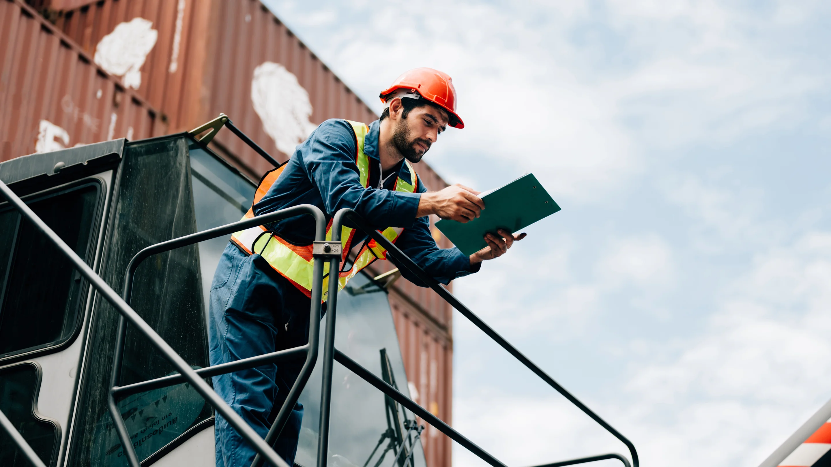 Logistics operator reviewing documentation at port with import containers from China